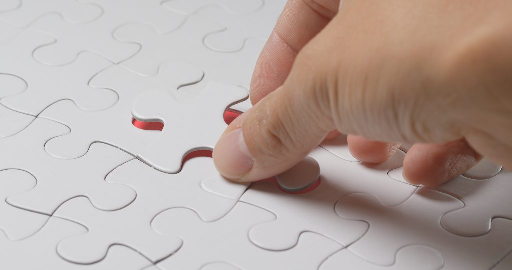 A white puzzle piece being inserted as the last missing piece